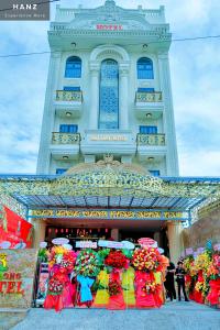 a building with a bunch of flowers in front of it at HANZ Bao Long Riverside Hotel in Ho Chi Minh City