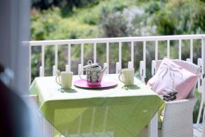 a table with a tea pot and cups on it at 116 - Casa Colorata vista mare, 500m dalla spiaggia - PARCHEGGIO PRIVATO GRATIS INCLUSO in Ospedaletti