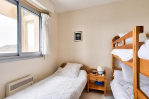 a bedroom with two bunk beds and a window at Appartement a moins de 100m de la plage du Bourg pour 4 personnes in Erquy