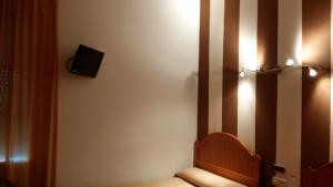 a room with a chair and a tv on the wall at Hotel Arcos-Coruña in Arcos de la Frontera