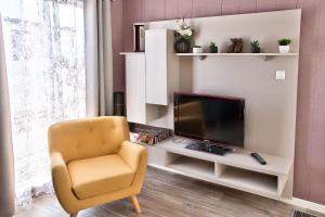 a living room with a chair and a television at Joli Chalet a Bretignolles sur mer pour 6 personnes in Brétignolles-sur-Mer