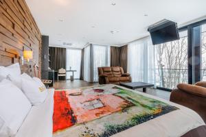 ein Hotelzimmer mit einem großen Bett und einem Wohnzimmer in der Unterkunft Bioli Wellness Resort in Kojori