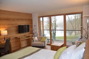 um quarto com uma cama, uma secretária e uma televisão em Hotel Le Caballin em Vogelgrun