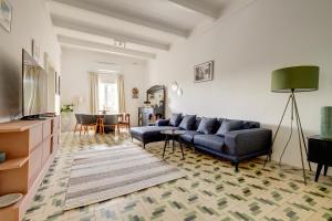 ein Wohnzimmer mit einem blauen Sofa und einem TV in der Unterkunft Stylish Apartment steps from the Capital in Floriana