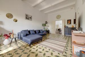 ein Wohnzimmer mit einem blauen Sofa und einem Teppich in der Unterkunft Stylish Apartment steps from the Capital in Floriana