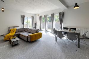 ein Wohnzimmer mit Sofa und Tisch in der Unterkunft Modern 4 bedroom near Warsaw parking/wifi/200m2 in Marki