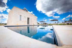 a pool in front of a building with a blue sky at Esclusive luxury private trulli in Martina Franca