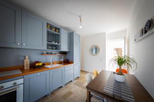 a kitchen with blue cabinets and a wooden table at Esclusive luxury private trulli in Martina Franca
