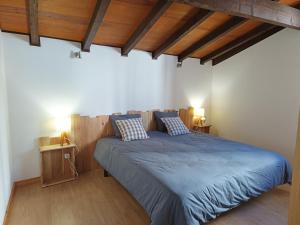 Un dormitorio con una cama con sábanas azules y techos de madera. en Casa Agrícola Do Limonete, en Figueira da Foz
