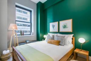 a bedroom with a green wall with a bed at Tribeca 1BR w Gym Doorman Rooftop garden NYC-52 in New York