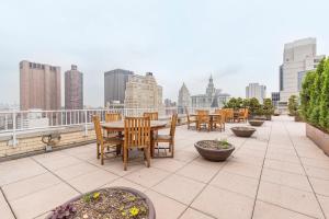 a patio with tables and chairs on a roof at Tribeca 1BR w Gym Doorman Rooftop garden NYC-52 in New York