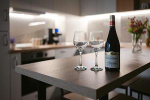 uma garrafa de vinho e dois copos de vinho numa mesa em SummerTime Tomis Villa Studio Mamaia Nord em Năvodari