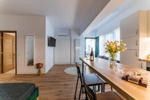 uma cozinha e sala de estar com mesa e cadeiras em SummerTime Tomis Villa Studio Mamaia Nord em Năvodari
