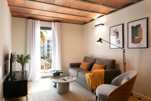 a living room with a couch and a large window at Aspasios Las Ramblas Apartments in Barcelona