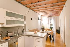 uma cozinha com armários brancos e um tecto de madeira em Aspasios Las Ramblas Apartments em Barcelona