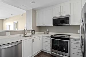 a kitchen with white cabinets and a sink and a microwave at Santana Row 2br w gym pool nr highways SFO-1156 in San Jose