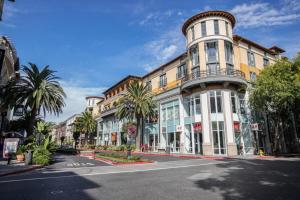 a large building on a city street with palm trees at Santana Row 2br w gym pool nr highways SFO-1156 in San Jose