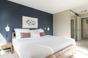 ein Schlafzimmer mit einem großen weißen Bett und einer blauen Wand in der Unterkunft Santa Clara 1BR w Pool Gym nr Caltrain Mall SFO-308 in Santa Clara