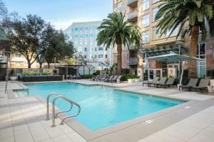a swimming pool with chairs and trees and buildings at Mountain View 2BR w Gym Lounge nr Highways SFO-1080 in Los Altos