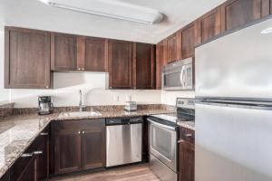 a kitchen with wooden cabinets and stainless steel appliances at Palo Alto 1br w gym pool bbq nr tech HQs SFO-1256 in Palo Alto