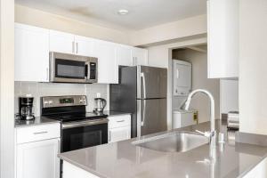 a kitchen with white cabinets and a stainless steel refrigerator at San Jose - The Alameda 2br w gym pool SFO-1153 in San Jose