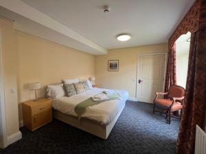 a hotel room with a bed and a chair at Ushaw Historic House, Chapels & Gardens in Durham