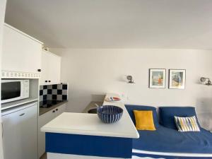 a kitchen with a blue and white couch in a room at Joli appartement tout confort près de la plage in Fouesnant +2 photos