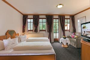 a hotel room with two beds and a flat screen tv at Hotel Gabriela in Serfaus