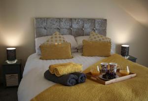 een bed met een dienblad met handdoeken en drankjes erop bij Ayr Loft Apartment with Fabulous Views in Ayr