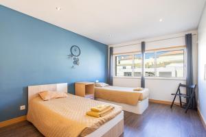 1 dormitorio con 2 camas y pared azul en Apartamento Correeira Deluxe by Umbral, en Albufeira