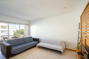 ein Wohnzimmer mit einem Sofa und einem Stuhl in der Unterkunft Apartamento Correeira Deluxe by Umbral in Albufeira