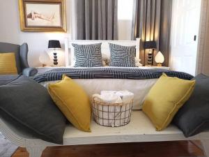 Una cama con almohadas amarillas y azules en un dormitorio en La Damon 2 en Paarl