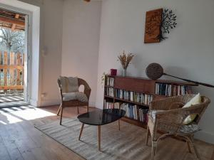 ein Wohnzimmer mit einem Tisch, Stühlen und einem Bücherregal in der Unterkunft Avol d'oiseau in Villers-Farlay