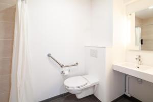 a white bathroom with a toilet and a sink at B&B HOTEL Bordeaux Saint André de Cubzac in Saint-André-de-Cubzac