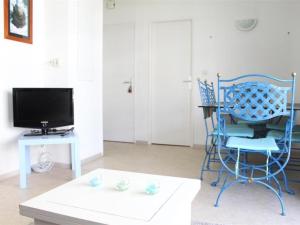 ラ・ロシェルにあるAppartement La Rochelle, 2 pièces, 2 personnes - FR-1-246-51のリビングルーム(青い椅子、テレビ付)