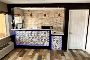 a bar in a kitchen with a brick wall at Days Inn by Wyndham Orange in Orange