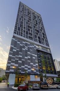 um edifício alto com carros estacionados em frente em Chambers Kuala Lumpur by Five Senses em Kuala Lumpur