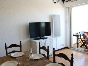 comedor con mesa y TV de pantalla plana en Appartement Port-la-Nouvelle, 3 pièces, 6 personnes - FR-1-229C-746, en Port-la-Nouvelle