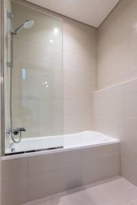 bagno bianco con doccia e vasca di Dream holiday home+private pool a Ras al Khaimah
