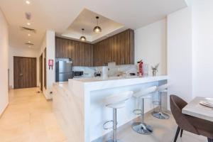 a kitchen with a bar with stools and a table at Dream holiday home+private pool in Ras al Khaimah