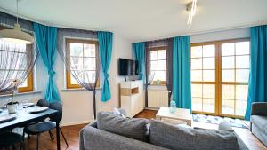 カルパチにあるApartamenty Every Sky Karpacz Prusa 2b/9の青いカーテンとソファのあるリビングルーム