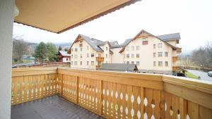カルパチにあるApartamenty Every Sky Karpacz Prusa 2b/9の木製のフェンスと一部の建物が備わるバルコニー