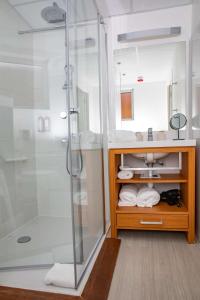 een badkamer met een douche en een wastafel bij Best Western Arcachon Le Port in Arcachon