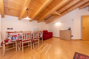 ein Wohnzimmer mit einem Tisch und einem roten Sofa in der Unterkunft Casa Milena in Pozza di Fassa