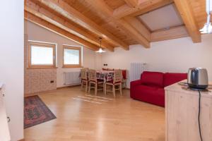- un salon avec un canapé rouge et une table dans l'établissement Casa Milena, à Pozza di Fassa