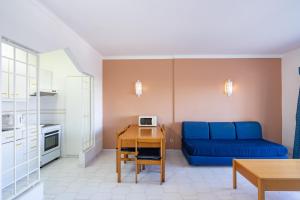 un soggiorno con divano blu e tavolo di Sunholidays Apartment by Umbral ad Albufeira
