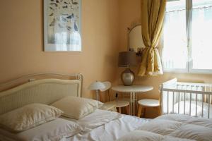 sypialnia z łóżkiem, łóżeczkiem dziecięcym i stołem w obiekcie Appartement familial pour 4 pers et 2 bébés face à la Baie w mieście Saint-Valéry-sur-Somme