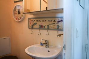 łazienka z umywalką i znakiem na ścianie w obiekcie Appartement familial pour 4 pers et 2 bébés face à la Baie w mieście Saint-Valéry-sur-Somme +25 zdjęć