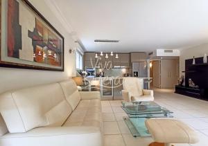 sala de estar con sofá blanco y mesa de cristal en Viva Riviera -14 Avenue Isola Bella, en Cannes