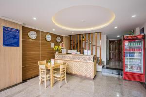 a restaurant with a table and chairs and clocks at Phú Xuân Hotel in Quy Nhon